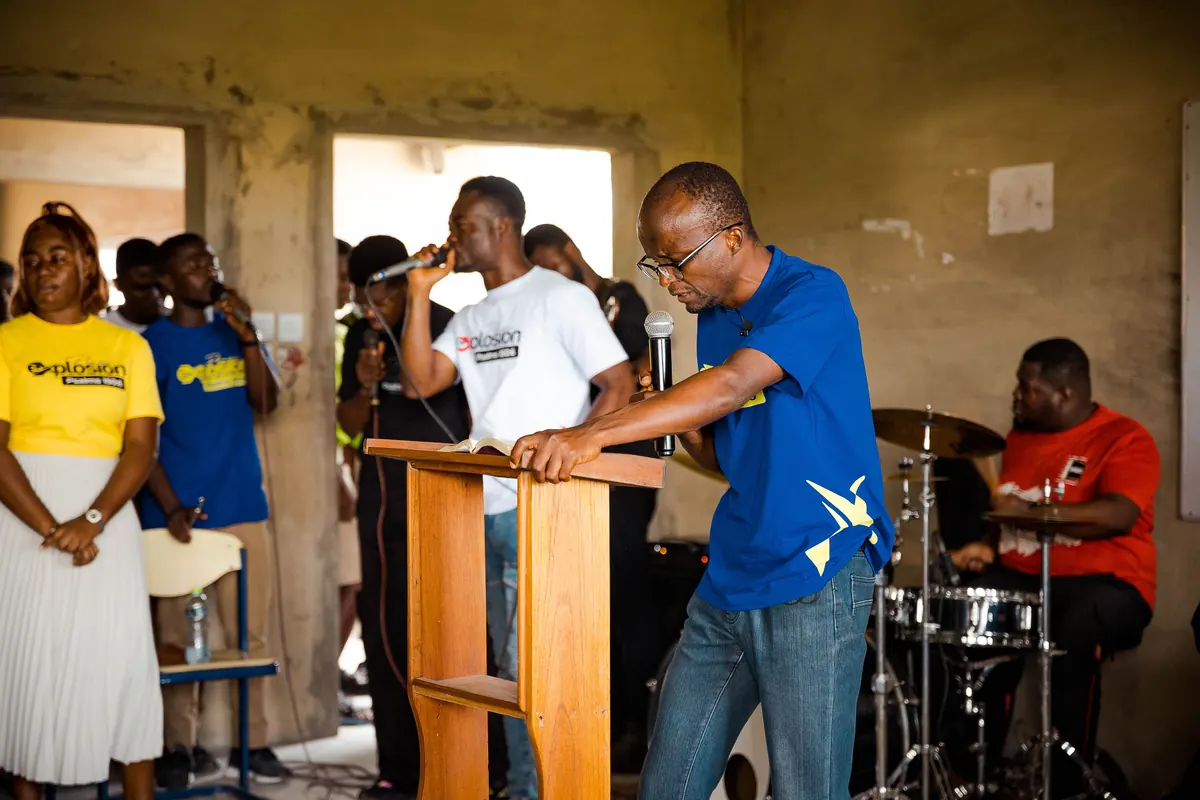 Speaker at the podium with the praise team and live band